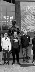 Os alunos do ITA junto ao Prof Fabio Ribeiro, da Purdue University, em frente à estátua de um famoso egresso de Purdue: o astronauta Neil Armstrong.